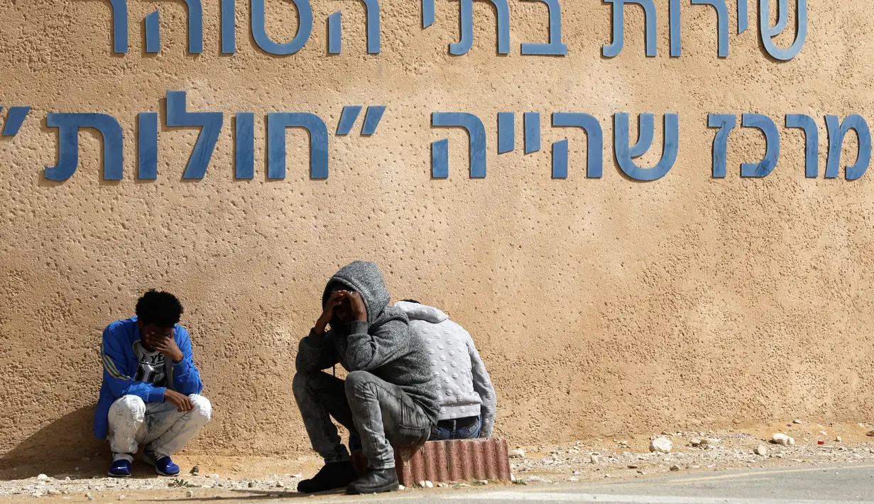 Migran Afrika duduk di sebelah pusat penahanan terbuka Holot sebelum melakukan aksi protes di Penjara Saharonim, Israel (22/2). Jika para migran Afrika tersebut tidak meninggalkan Israel, merekan akan mendekam di penjara. (AFP Photo/Menahem Kahana)