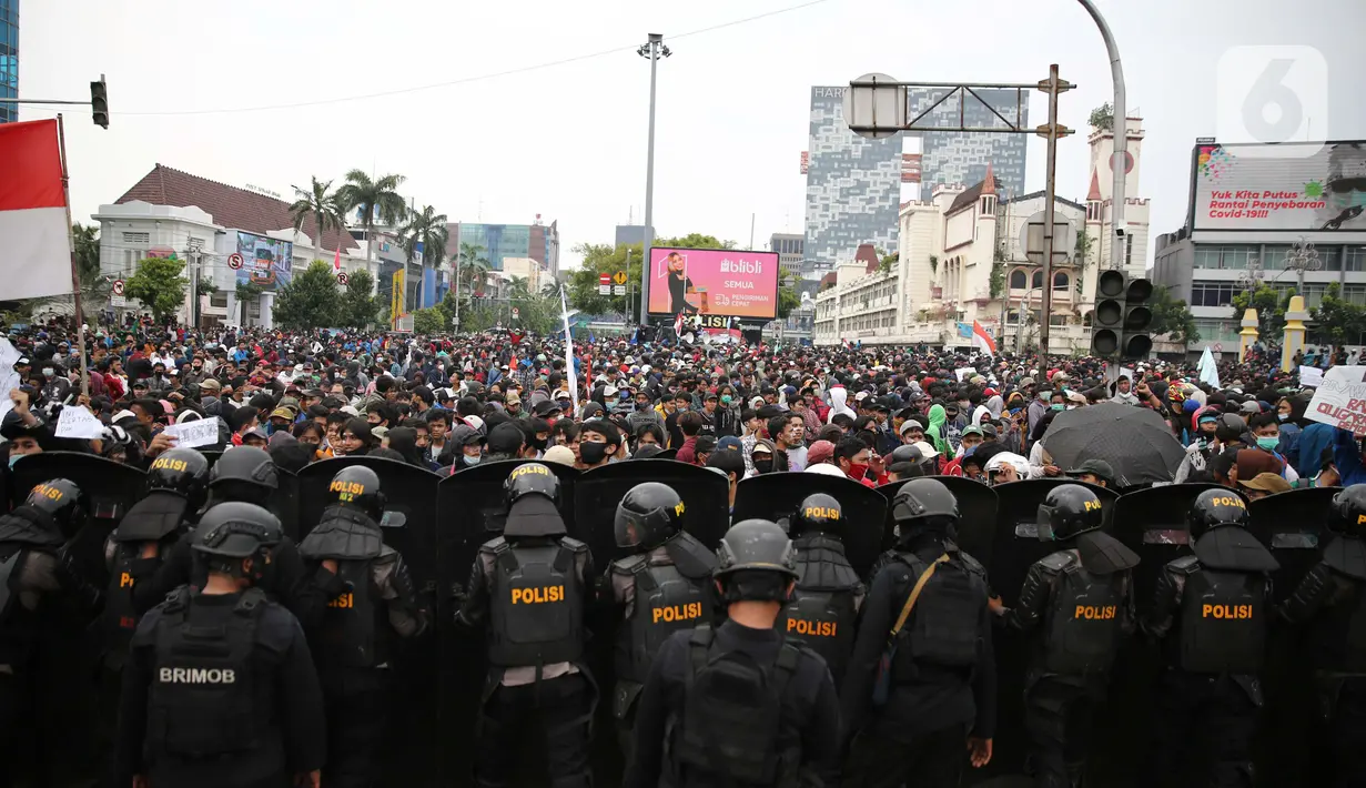 Polisi menjaga unjuk rasa menolak UU Cipta Kerja di kawasan Harmoni, Jakarta, Kamis (8/10/2020). UU Cipta Kerja yang disahkan beberapa waktu lalu memicu demonstasi sejumlah kalangan. (Liputan6.com/Faizal Fanani)