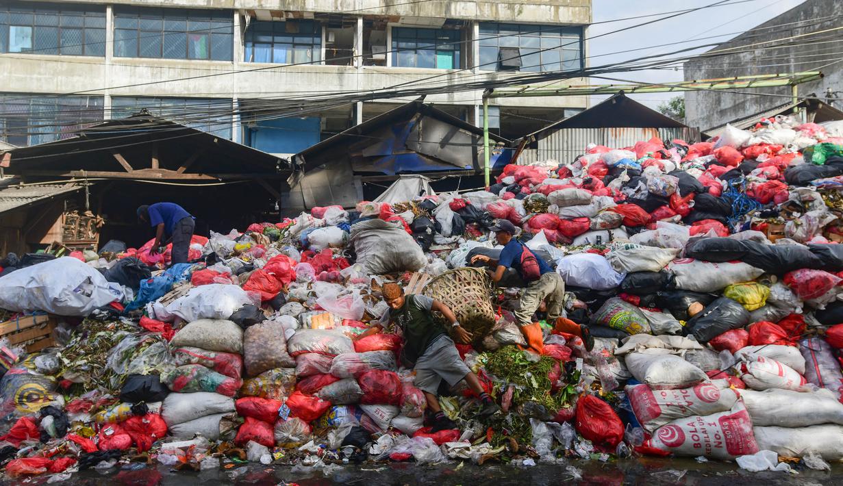 Krisis ini diakibatkan penutupan Tempat Pembuangan Akhir (TPA) sampah di Cipeucang di Serpong, Tangerang Selatan. Tampak dalam foto, pemulung saat berada di antara tumpukan sampah pada salah satu ruas jalan di kawasan Pasar Manggis, Ciputat, Tangerang Selatan, Senin (15/12/2025). (merdeka.com/Arie Basuki)