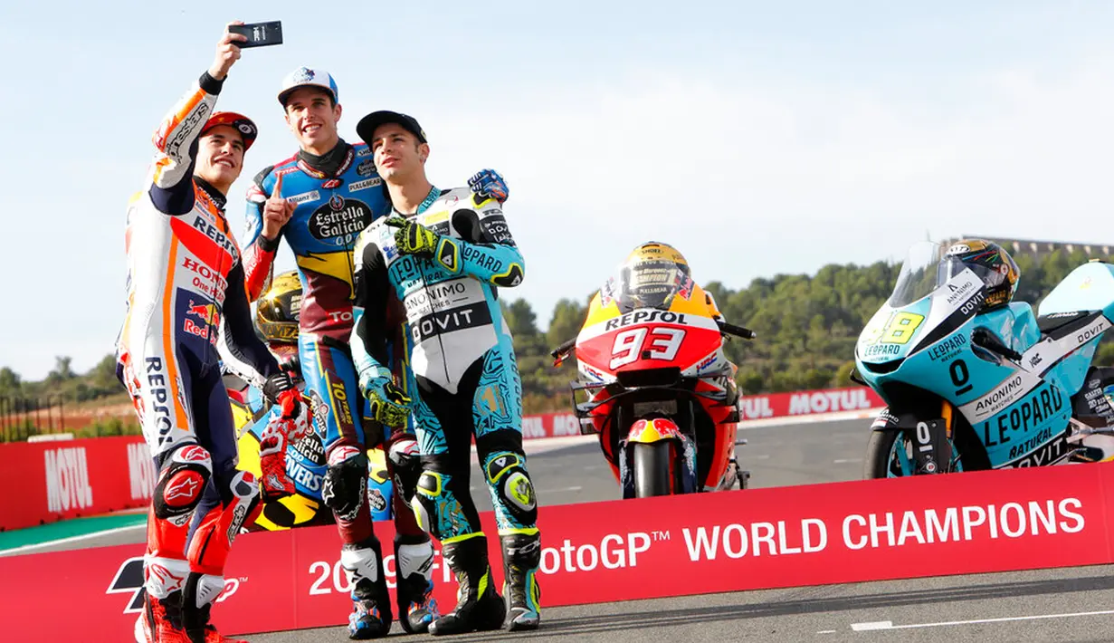 Pembalap MotoGP Marc Marquez (kiri) bersama pembalap Moto2 Alex Marquez (tengah) dan pembalap Moto3 Lorenzo Dalla Porta (kanan) berswafoto di depan Valencia Motorcycle Grand Prix, Spanyol, Minggu (17/11/2019). Ketiganya sukses merebut gelar juara dunia tahun 2019. (AP Photo/Alberto Saiz)