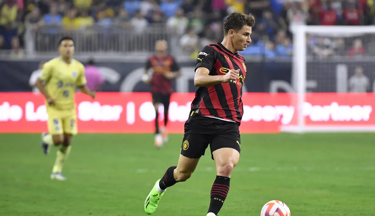 Penyerang Manchester City, Julian Alvarez berlari membawa bola saat bertanding melawan Club America pada pertandingan persahabatan Pra-Musim di NRG Stadium di Houston, Texas (20/7/2022). Manchester City menang tipis atas America 2-1. (AFP/Logan Riely)