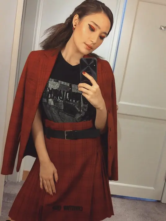 Berikan kesan unik pada midi skirt dan blazer yang bergaya ultra feminin. Tambahkan paduan t-shirt untuk hadirkan gaya yang berbeda dan anti membosankan.  [Foto: Tatjana Saphira/ Instagram].