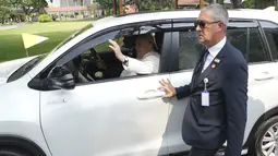 Paus yang memakai mobil Innova Zenix sempat membuka kaca mobilnya dan melambaikan tangan kepada awak media. (AP Photo/Achmad Ibrahim, Pool)