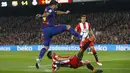 Aksi pemain FC Barcelona, Luis Suarez melepaskan tembakan saat diadang pemain Girona pada La Liga Santander di Camp Nou stadium, Barcelona, (24/2/2018). Barcelona menang telak 6-1. (AP/Manu Fernandez)