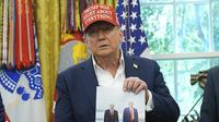 Presiden Donald Trump memperlihatkan sebuah foto dirinya bersama Presiden Rusia Vladimir Putin di Oval Office, Gedung Putih, Washington, Jumat (22/8/2025). (Dok. AP Photo/Jacquelyn Martin)&nbsp;&nbsp;&nbsp;