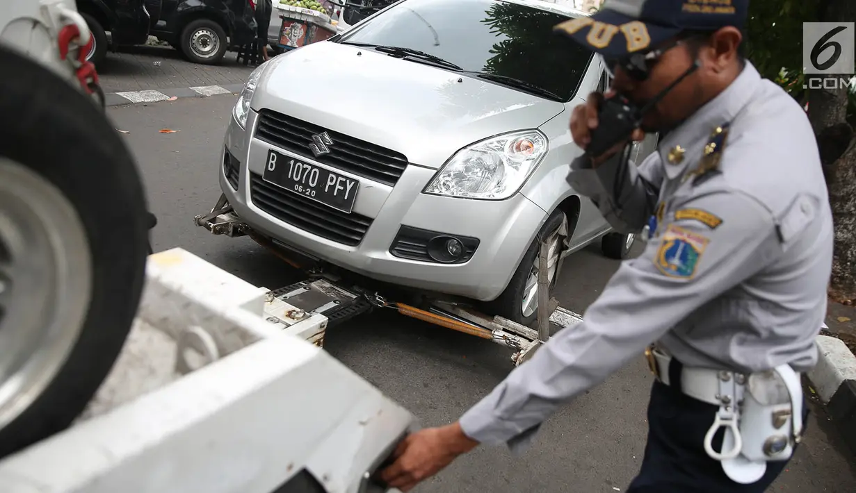 Petugas Dinas Perhubungan bersiap menderek mobil yang terjaring parkir liar di kawasan Pasar Baru, Jakarta, Kamis (14/12). Parkir sembarang di pinggir jalan ini membuat kesemrawutan dan menimbulkan kemacetan. (Liputan6.com/Immanuel Antonius)
