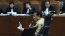 Terdakwa dugaan korupsi proyek e-KTP, Setya Novanto membaca catatan saat menjadi saksi pada sidang lanjutan di Pengadilan Tipikor, Jakarta, Kamis (22/3). Sidang mendengar kesaksian terdakwa. (Liputan6.com/Helmi Fithriansyah)