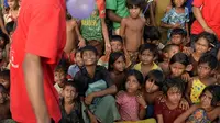 Kelompok teater Drama Therapy mengenakan kostum badut menghibur anak-anak pengungsian Rohingya di kamp pengungsi Kutupalong, Bangladesh (28/10). (AFP Photo/Tauseef Mustafa)