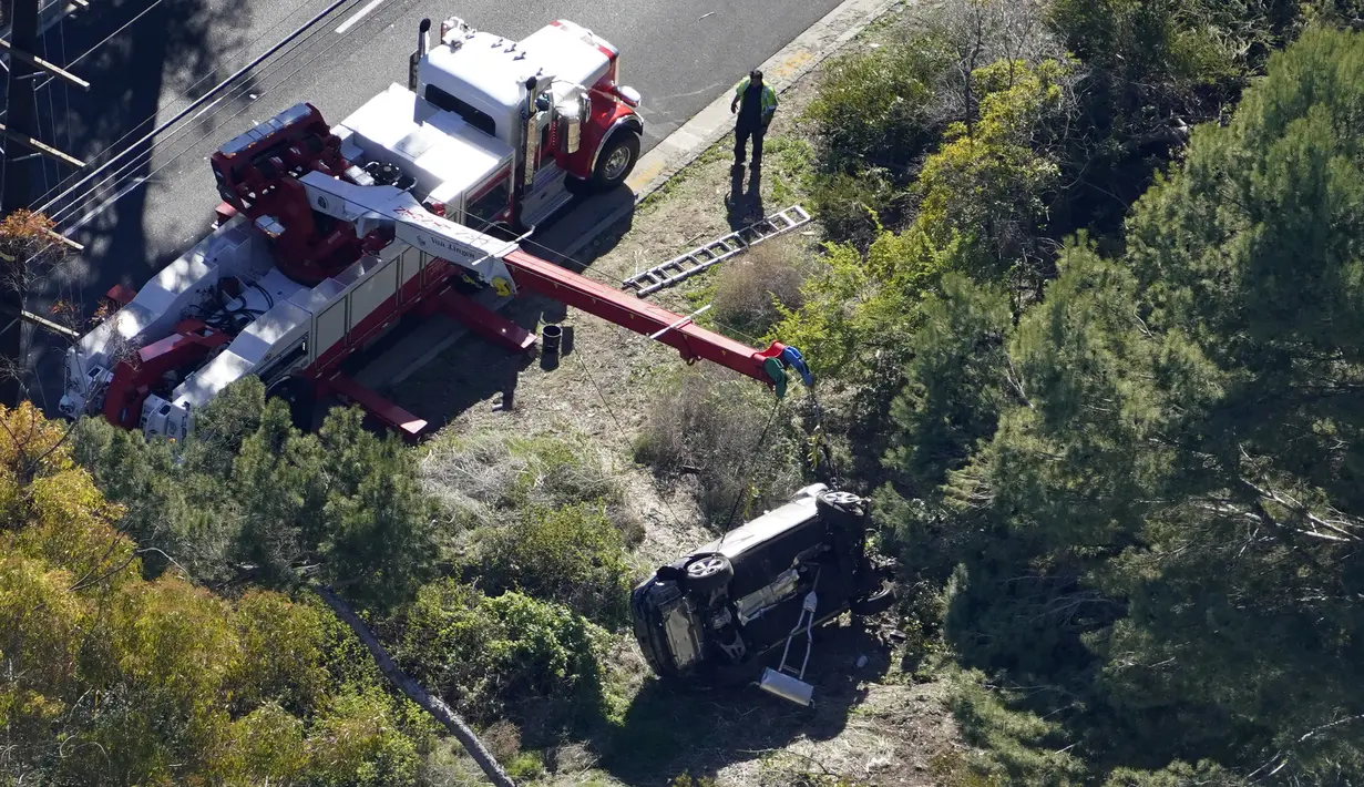Sebuah mobil tergeletak miring setelah kecelakaan yang melibatkan pegolf terkenal Tiger Woods di Rancho Palos Verdes, California, pinggiran Los Angeles, Selasa (23/2/2021). Pria bernama asli Eldrick Tont Woods tersebut ditolong melalui windshield yang harus dipecahkan. (AP Photo/Mark J. Terrill)