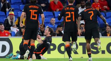 Striker Belanda Wout Weghorst (tengah) merayakan dengan rekan setimnya setelah mencetak gol ke gawang Wales selama pertandingan grup A4 UEFA Nations League di stadion Cardiff City di Cardiff, Wales selatan, Kamis (9/6/2022). Belanda menang tipis atas Wales 2-1. (AFP/Geoff Caddick)