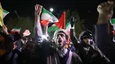 Para pengunjuk rasa mengibarkan bendera Iran dan bendera Palestina saat mereka berkumpul di depan Kedutaan Besar Inggris di Teheran pada tanggal 14 April 2024. (ATTA KENARE/AFP)