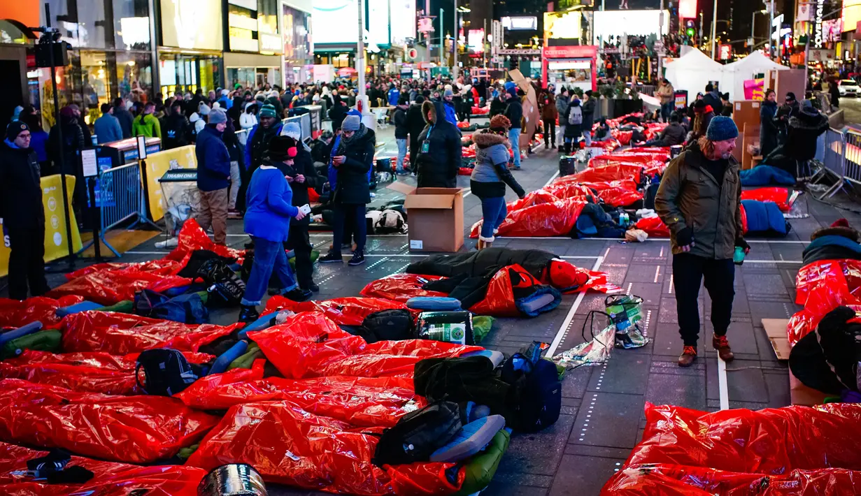 Orang-orang bersiap-siap untuk tidur di area terbuka dalam acara World's Big Sleep Out di Times Square, New York, 7 Desember 2019. Aksi di beberapa kota besar dunia ini sebagai bagian dari upaya penggalangan dana untuk membantu para tunawisma di banyak negara. (Eduardo Munoz Alvarez/AFP)