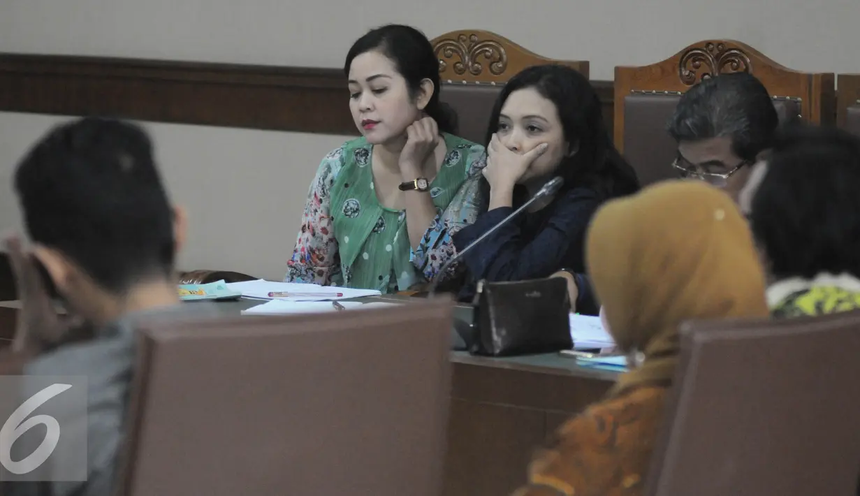 Terdakwa kasus dugaan suap proyek pada Kementerian Pekerjaan Umum dan Perumahan Rakyat, Dessy Ariyanti Edwin (kiri) dan Julia Prasetyarini (tengah) menjalani persidangan di Pengadilan Tipikor, Jakarta, Kamis (21/7). (Liputa6.com/Helmi Afandi)