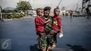 Salah satu personel TNI-AD menggendong anak kembarnya di Pelabuhan Kolinlamil, Jakarta, Senin (9/5). Sebanyak 450 personel TNI-AD dari Satgas Yonif Para Raider 330 inf 1 Kostrad dilepas untuk misi pengamanan perbatasan RI-PNG. (Liputan6.com/Faizal Fanani)