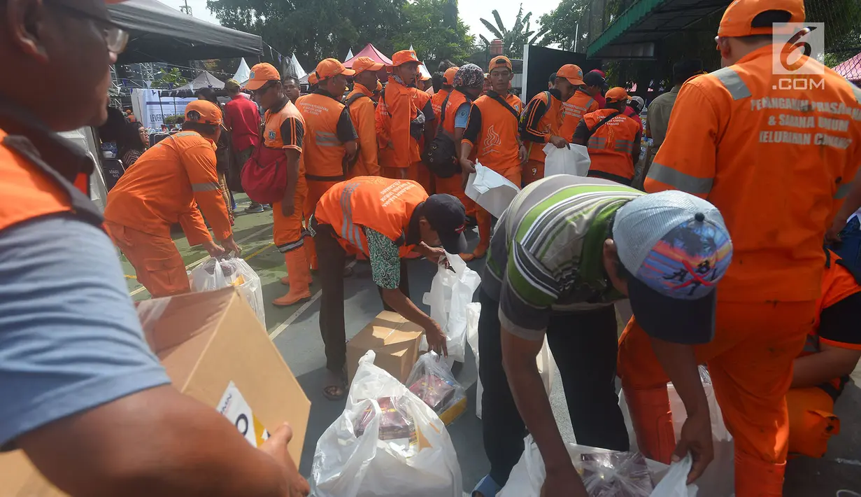 Petugas Penangganan Prasarana dan Saran Umum (PSSU) atau pasukan oranye mendapatkan sembako gratis di Jakarta, Jumat (3/8). Pembagian sembako gratis tersebut dalam rangka menyambut HUT ASABRI ke-47 tahun. (Merdeka.com/Imam Buhori)