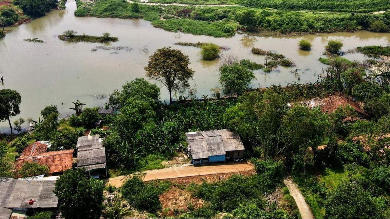 Sebuah pemandangan memprihatinkan yang potret dari udara memperlihatkan tumpukan sampah yang menjulang tinggi hingga menghalangi aliran sungai dan menyebabkan pemukiman warga di sekitar Depok terendam banjir pada 7 Mei 2024. Foto: AFP / Bay Ismoyo