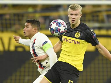 Striker Borussia Dortmund, Erling Braut Haaland, berebut bola dengan bek Paris Saint-Germain, Thiago Silva, pada leg pertama 16 besar Liga Champions di Signal Iduna Park, Dortmund, Rabu (19/2) dini hari WIB. Dortmund menang 2-1 atas PSG.(AFP/Ina Fassbender)