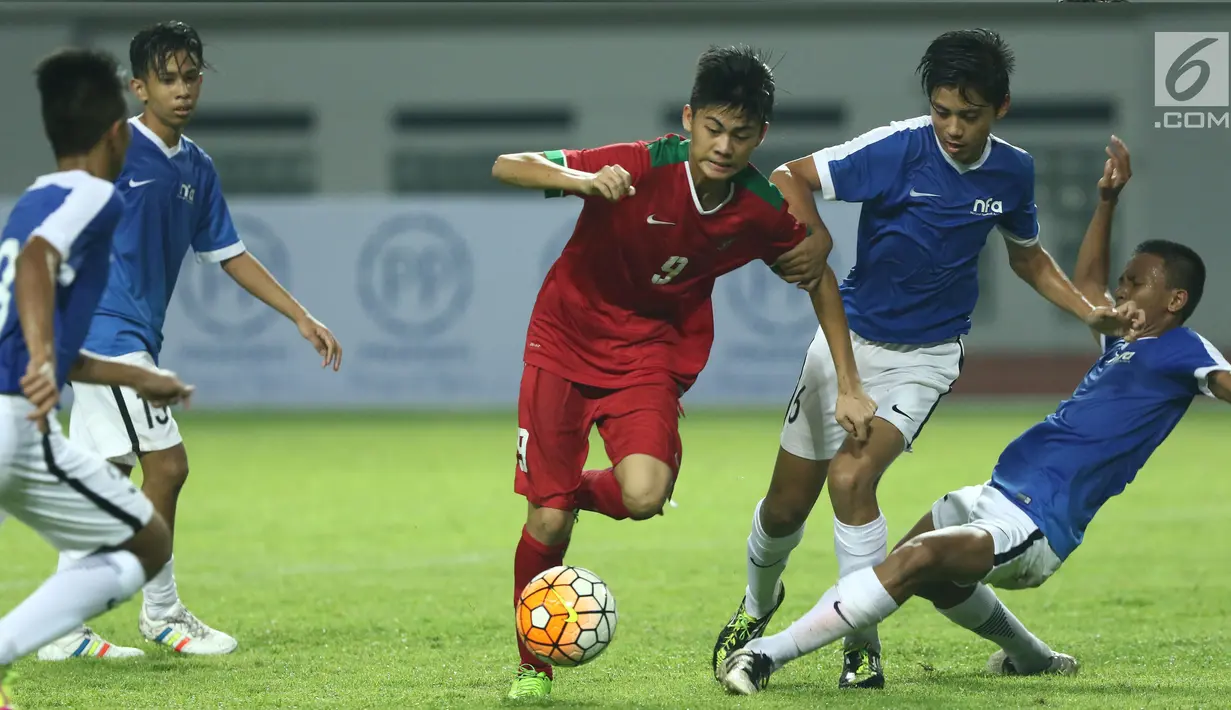 Penyerang Timnas Indonesia U-16, Rendi Juliansyah (tengah) mencoba melewati kawalan pemain Singapura U-16 saat laga persahabatan di Stadion Wibawa Mukti, Kab Bekasi, Kamis (8/6). Indonesia U-16 menang telak 4-0. (Liputan6.com/Helmi Fithriansyah)