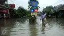 Warga melintasi banjir di perumahan Pondok Hijau Permai, Bekasi, Senin (20/2). Ketinggian air yang merendam perumahan Pondok Hijau Permai mencapai 30-70 cm. (Liputan6.com/Gempur M. Surya)