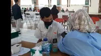 Nampak salah seorang santri pesantren Cipasung, Tasikmalaya, tengah melaksanakan proses vaksinasi covid-19 yang digelar Polres Tasikmalaya, Jawa Barat tersebut. (Liputan6.com/Jayadi SupriadinP