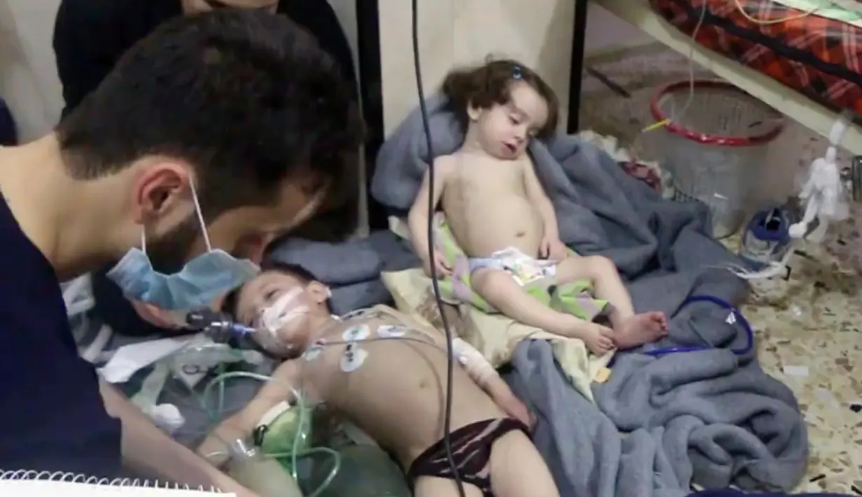 Petugas medis merawat balita menyusul dugaan serangan senjata kimia di Kota Douma, dekat Damaskus, Suriah, Minggu (8/4). Korban tewas serangan gas beracun termasuk anak-anak. (Syrian Civil Defense White Helmets via AP)