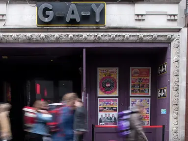Pejalan kaki melintas di depan bar 'GAY', Soho, London, Senin (27/2). Soho merupakan kawasan yang terkenal sebagai distrik hiburan dan surga bagi para homoseksual setelah dilegalkan sejak 50 tahun lalu. (AFP Photo/ JUSTIN TALLIS)
