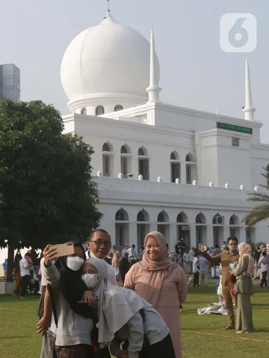 Umat muslim berswafoto usai melaksanakan shalat Idul Fitri 1442 H di Lapangan Masjid Agung Al Azhar, Jakarta, Kamis (13/5/2021). Ribuan umat muslim melaksanakan shalat Idul Fitri 1442 H di Lapangan Masjid Agung Al Azhar dengan menerapkan protokol kesehatan ketat. (Liputan6..com/Helmi Fithriansyah)