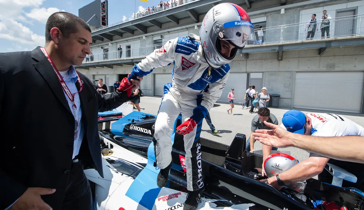 Penyanyi Lady Gaga keluar dari mobil balap usai melakukan satu putaran saat acara pembukaan kejuaraan Indianapolis 500 tahun 2016 di Indianapolis Motor Speedway, Amerika (29/5). (REUTERS/Thomas J. Russo-USA TODAY Sports)