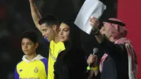 Cristiano Ronaldo bersama sang kekasih Georgina Rodriguez dan putranya Cristiano Ronaldo Jr naik panggung saat upacara penyambutan dirinya sebagai pemain baru Al Nassr di Stadion Mrsool Park, di ibu kota Saudi, Riyadh, Selasa (3/1/2023). (Fayez Nureldine / AFP)