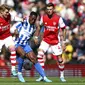 Pemain Arsenal Martin Odegaard (kiri), berduel memperebutkan bola dengan pemain Brighton Danny Welbeck dalam pertandingan lanjutan Liga Inggris di Stadion Emirates, Sabtu (9/4/2022) malam WIB. (AP Photo/Ian Walton)