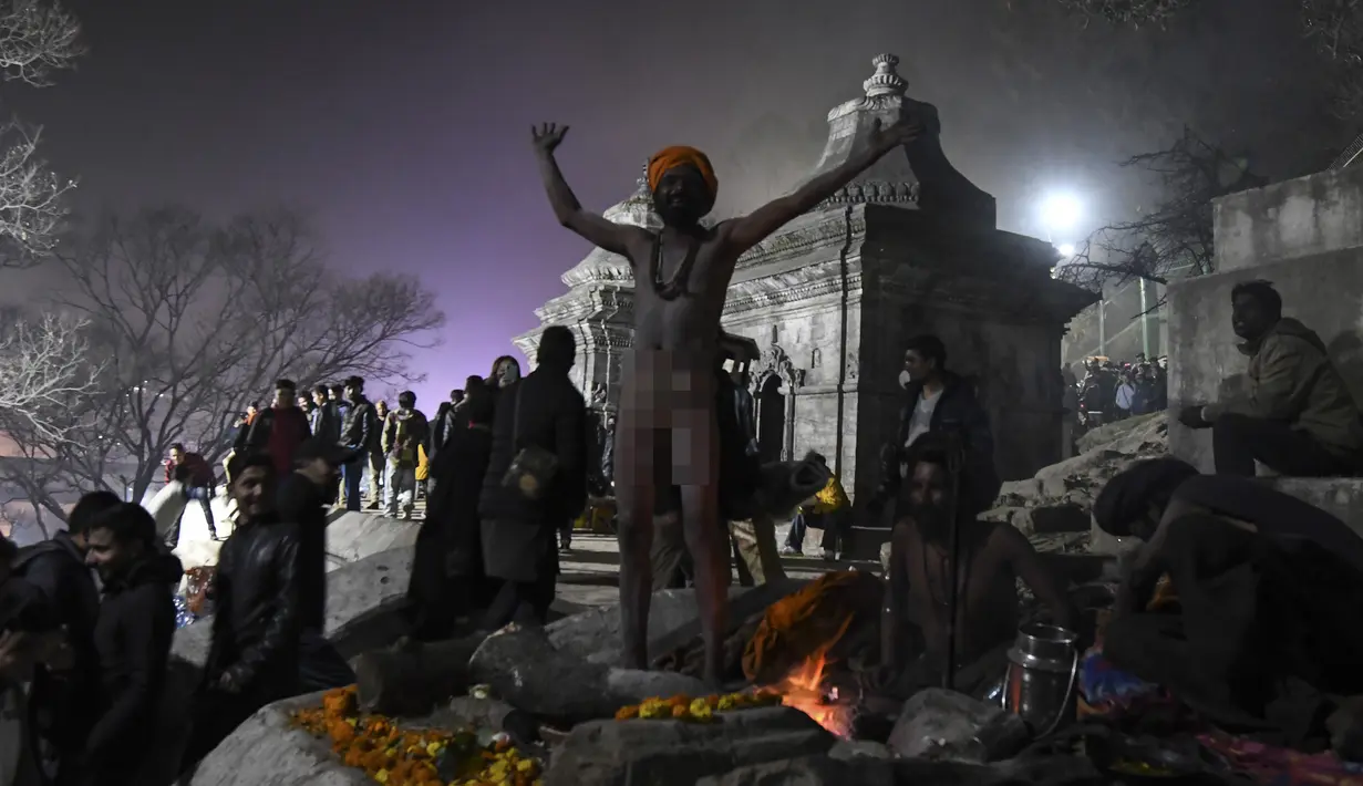 Sadhu (orang suci Hindu) duduk di sebelah BONfire dekat Kuil Pashupatinath pada malam festival Hindu Maha Shivaratri di Kathmandu (20/2/2020). Festival ini  didedikasikan untuk 'Malam Besar Siwa', dewa Hindu yang berdoa dan berpuasa bagi orang percaya. (AFP/Prakash Mathema)