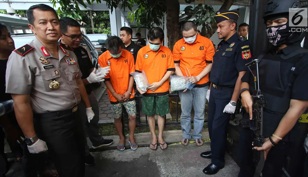 Tiga tersangka dihadirkan di Polda Metro Jaya, Jakarta, Kamis (2/11). Subdit II Ditresnarkoba Polda Metro Jaya mengamankan barang bukti 86 kg metamfetamina, 100 gram ketamine, 99 gram serbuk berwarna putih dan oranye. (Liputan6.com/Immanuel Antonius)