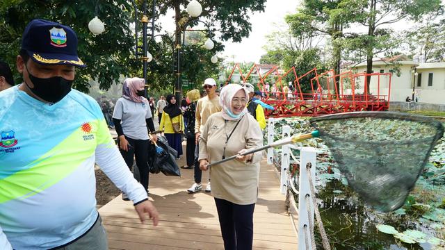 Ketua DPRD Garut Euis Ida Wartiah bersama wakil rakyat lainnya tengah memungut sampah tanaman eceng gondok di kawasan wisata SItu Bagendit, Garut, Jawa Barat. (Liputan6.com/Jayadi Supriadin)