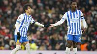Pemain Brighton, Kaoru Mitoma melakukan tos dengan Danny Welbeck pada laga lanjutan Liga Inggris 2024/2025 melawan Manchester United yang berlangsung di Old Trafford, Manchester, Inggris, Minggu (19/01/2025). (AP Photo/Dave Thompson)