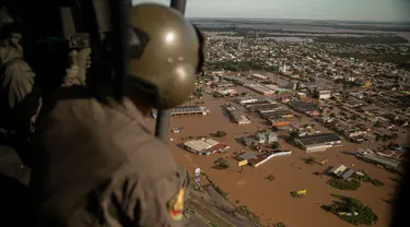 Seorang anggota militer mengamati dari helikopter jalanan yang terendam banjir di kota El Dorado do Sul, negara bagian Rio Grande do Sul, Brasil, pada tanggal 8 Mei 2024. (Carlos FABAL/AFP)