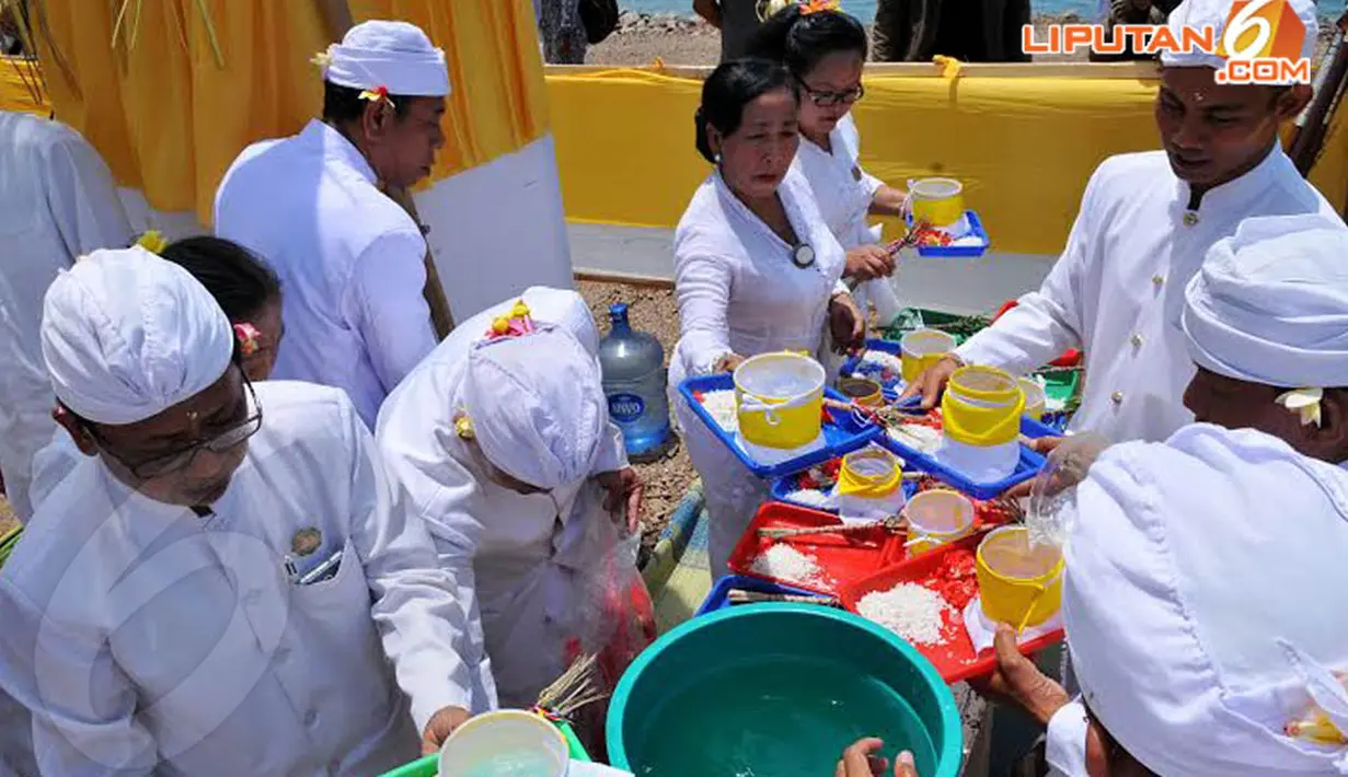 Air suci dan sejumlah bunga dan beras tampak disiapkan untuk selanjutnya didoakan (Liputan6.com/Andrian M Tunay)