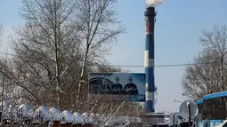 Sebuah poster yang menggambarkan para penambang duduk di dekat tambang batu bara Listvyazhnaya, dekat kota Belovo di wilayah Kemerovo (26/11/2021). Lebih dari 50 orang dilaporkan tewas setelah asap memenuhi tambang batu bara Siberia. (AFP/ Rostislav Netisov)