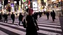 Orang-orang yang memakai masker berjalan di distrik Shibuya di Tokyo (19/1/2022). Pemerintah Jepang menyetujui pembatasan virus corona baru di sebagian besar negara, termasuk ibu kota untuk memerangi rekor infeksi yang dipicu oleh varian Omicron. (AFP/Behrouz Mehri)
