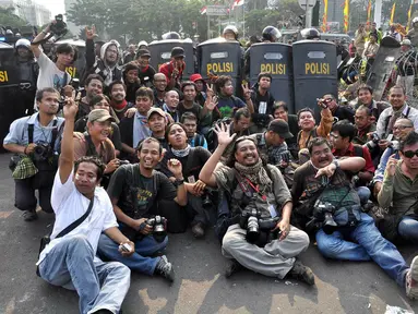 Sejumlah pewarta foto melakukan foto bersama usai demo di kawasan Patung Kuda, Jakarta, Kamis (21/8/14).(Liputan6.com/Miftahul Hayat)