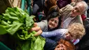 Warga mengambil sayur yang dibagikan secara gratis oleh petani di Buenos Aires, Senin (24/4). Aksi tersebut sebagai bentuk protes tingginya biaya hidup yang dianggap memberatkan petani. (AFP FOTO / Eitan ABRAMOVICH)