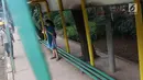 Seorang wanita menunggu di Halte Perum Tanjung Mas, Jakarta, Rabu (6/2). Proyek peninggian trotoar yang tidak diimbangi dengan renovasi halte menyebabkan bangku di halte menjadi pendek dan tidak layak untuk digunakan. (Liputan6.com/Immanuel Antonius)