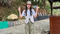 Saat mengunjungi Cimory Land, pemeran 40 tahun itu mengganti vest-nya menjadi warna beige.