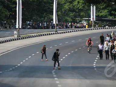 Sejumlah karyawan berjalan kaki untuk menuju kantornya di sekitar kawasan Bundaran HI, Jakarta, Rabu (22/4/2015). Sejumlah jalan utama di Jakarta ditutup total untuk sementara waktu terkait puncak Konferensi Asia-Afrika (KAA). (Liputan6.com/Faizal Fanani)