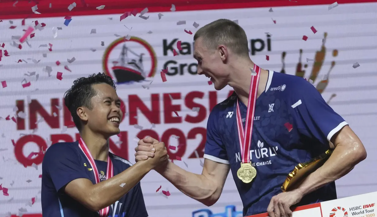 <p>Juara tunggal putra Denmark Viktor Axelsen berjabat tangan dengan runner up dari Indonesia Anthony Sinisuka Ginting saat penyerahan medali usai final tunggal putra Indonesia Open 2023 di Istora Senayan, Minggu (18/6/2023). (AP Photo/Tatan Syuflana)</p>
