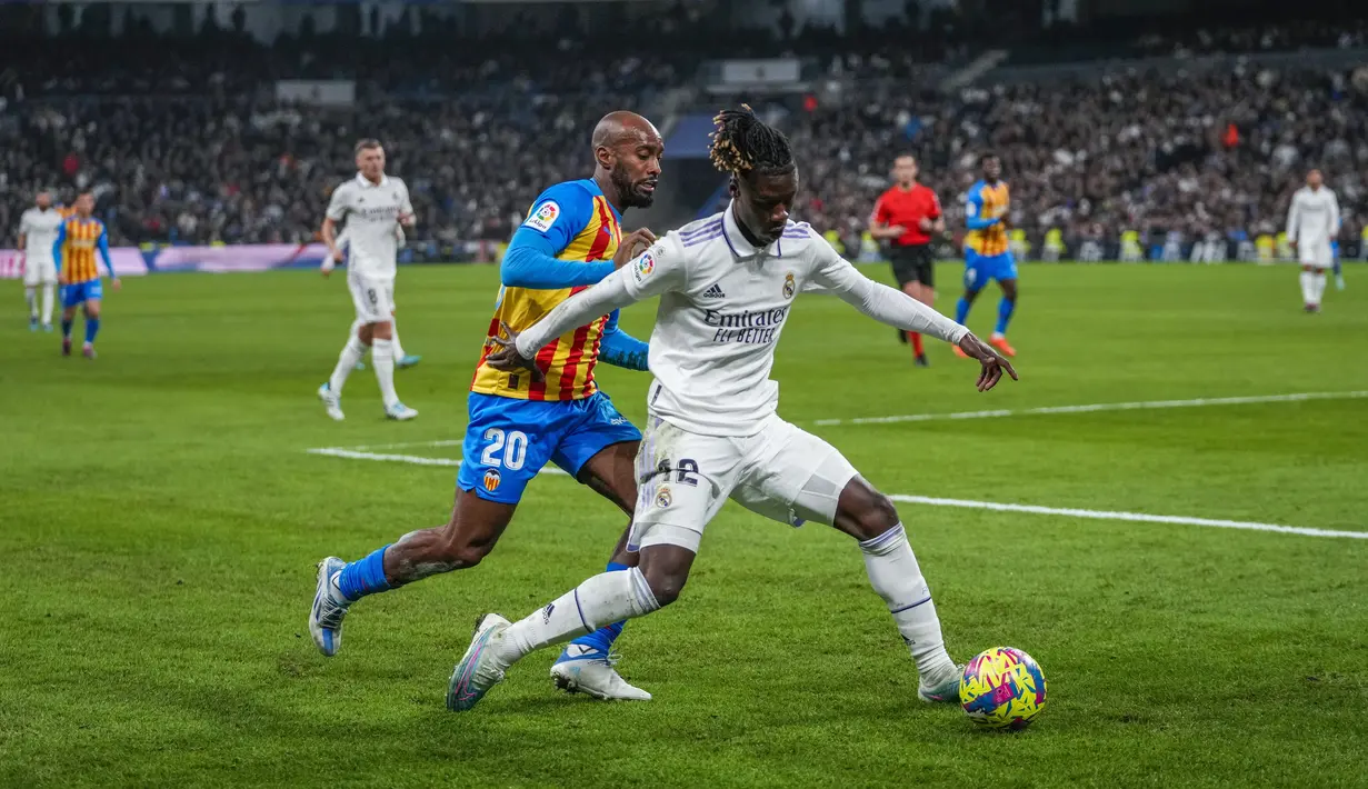 Gelandang Real Madrid, Eduardo Camavinga mengontrol bola dari kawalan pemain pemain Valencia, Dimitri Foulquier selama pertandingan La Liga Spanyol di stadion Santiago Bernabeu di Madrid, Jumat (3/2/2023). Real Madrid menang atas Valencia 2-0 . (AP/Bernat Armangue)