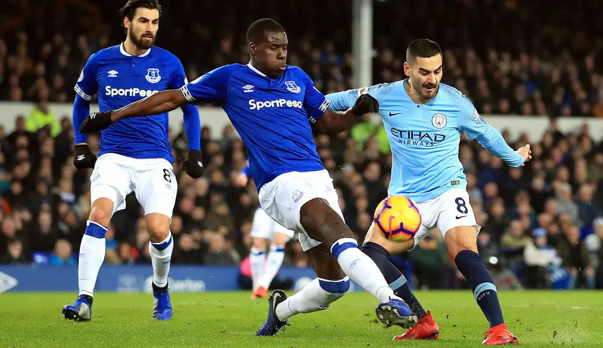 Gelandang Manchester City, Ilkay Gundogan berebut bola dengan pemain Everton, Kurt Zouma selama pertandingan lanjutan Liga Inggris di Goodison Park Stadium (6/2). Hasil ini membuat City memuncaki klasemen Liga Inggris. (Peter Byrne/PA via AP)