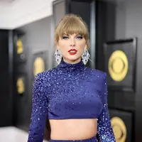 Taylor Swift saat berjalan di karpet merah ajang Grammy Awards 2023 di Crypto.com Arena, Los Angeles, AS, Senin (6/2/2023) pagi waktu Indonesia. Melansir dari ET Online, para penggemar pun dengan cepat menelusuri bahwa gaun tersebut  memiliki warna yang sama dengan gaun GRAMMY era Fearless-nya dan seperti penampilan GRAMMY 1989-nya, itu adalah pakaian dua potong (two-piece). (Neilson Barnard / Getty Images via AFP))