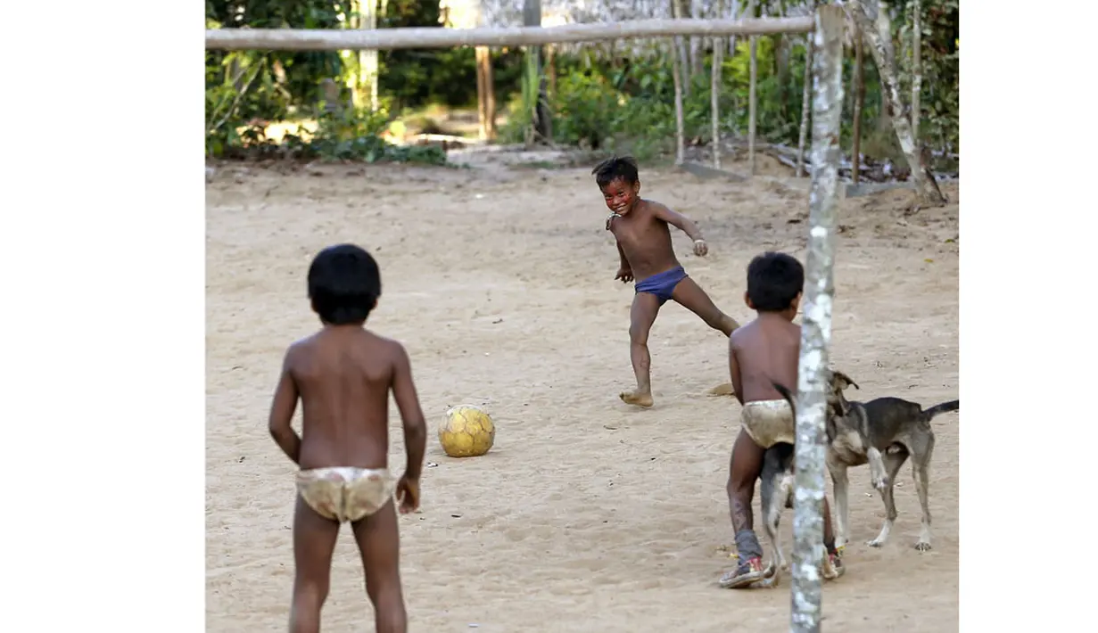 Beberapa anak dari suku Amazon Tatuyo terlihat asyik bermain bola di desanya, Rio Negro (Black River) tidak jauh dari kota tempat pertandingan Piala Dunia 2014, Manaus City, Brasil (23/6/2014). (REUTERS/Andres Stapff)