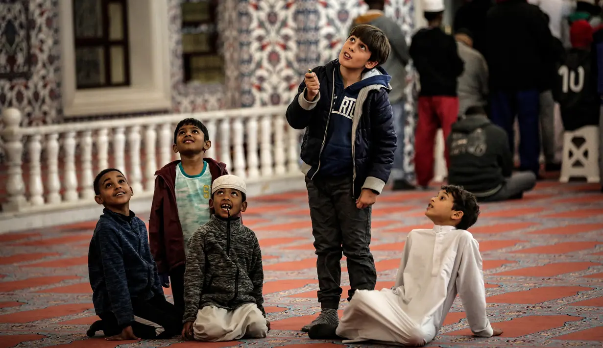 Sejumlah anak bersiap melaksanakan salat tarawih malam pertama Ramadan 1439 H di Masjid Nizamiye di Midrand, Johannesburg, Afrika Selatan (16/5). Masjid ini diresmikan oleh Presiden Afrika Selatan Jacob Zuma pada 4 Oktober 2012. (AFP Photo/Gulshan Khan)