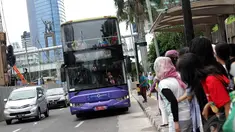 Sejumlah calon penumpang menunggu bus tingkat wisata di kawasan Bundaran HI, Jakarta, Kamis (1/1/2015). (Liputan6.com/Faizal Fanani)